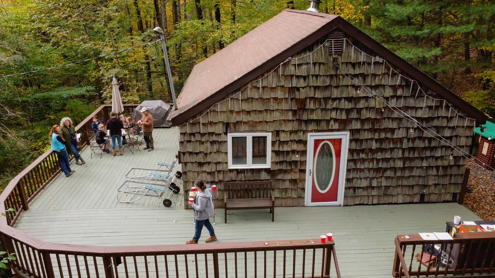 Guests gathered on the cabin deck at the forest edge during a fall visit