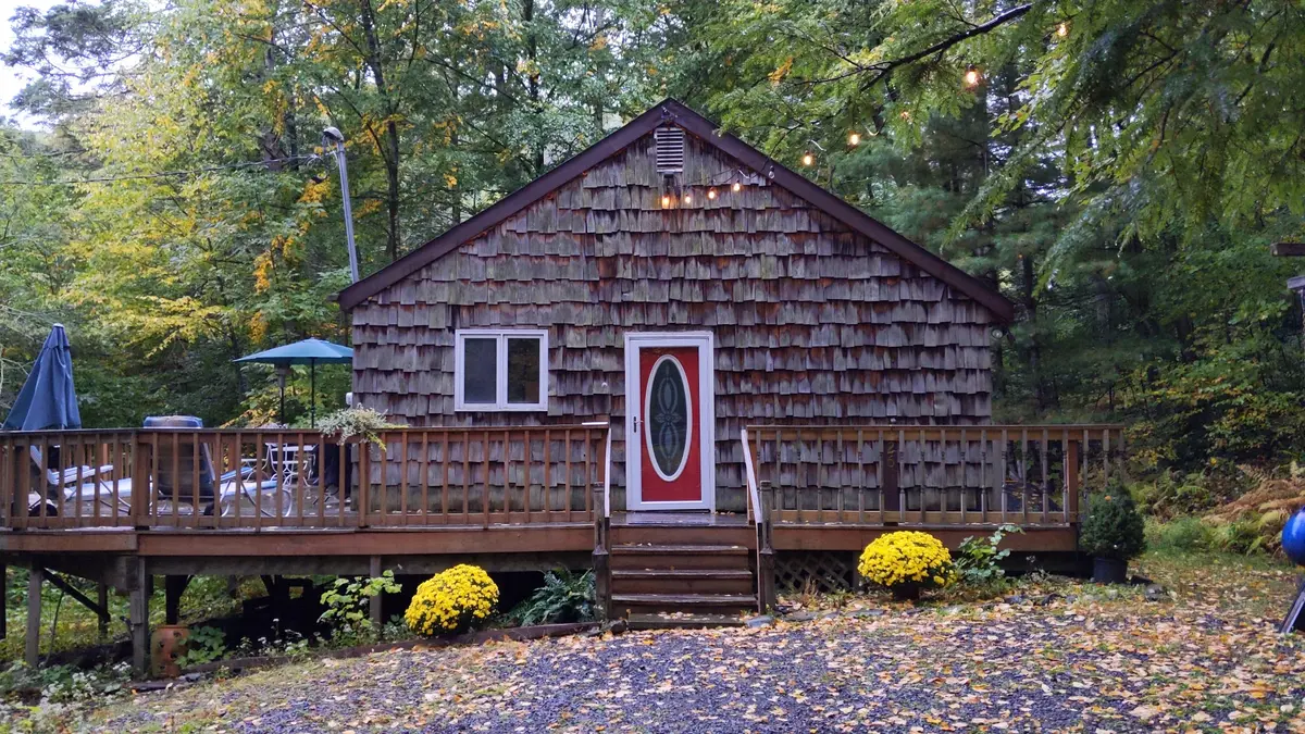 The red front door with string lights glowing on a rainy autumn evening