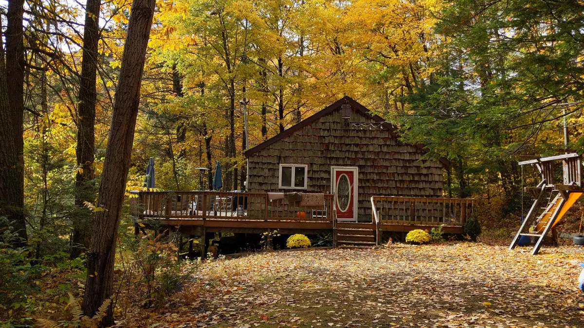 The cabin and deck under peak-gold October foliage